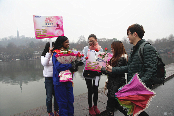 外籍女工西湖邊“關(guān)愛女工”行為體驗(yàn) 游人的熱情擁抱累得她胳膊抬不起來